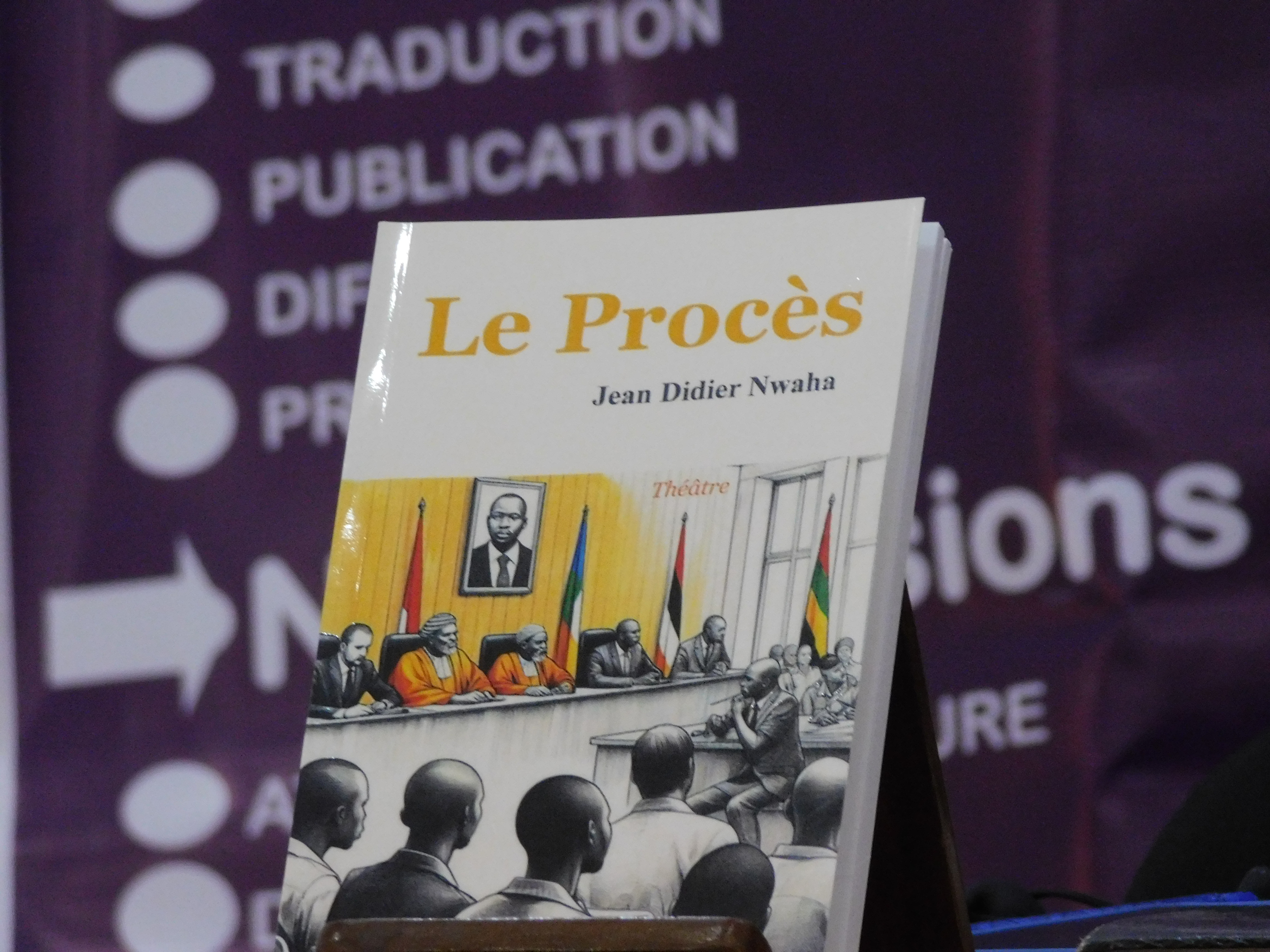 Couverture du livre 'Le Procès' de Jean Didier Nwaha, présentant une scène de tribunal avec des juges et des témoins.